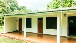 A building with a covered porch, multiple doors, and a tiled floor.
