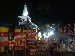 A temple with a white spire and colorful flags.