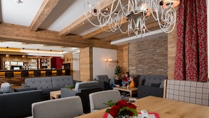 Un intérieur moderne avec un plafond en bois, un espace bar et différents types de sièges.