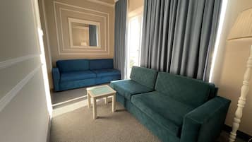 Una sala de estar con un sofá azul, un sofá verde y una mesita.