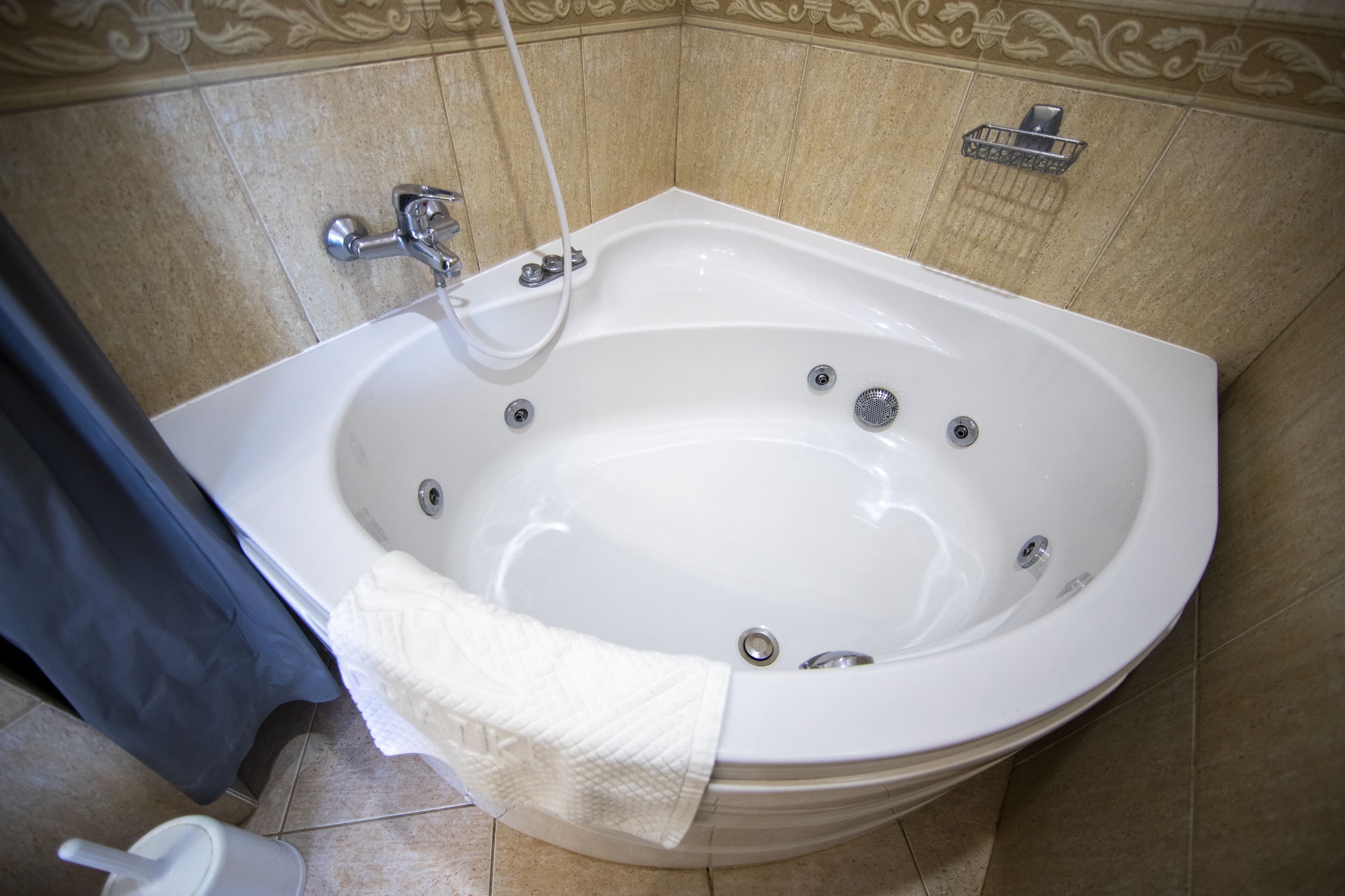 Ein modernes Badezimmer mit einer großen Badewanne, einer Duschbrause und einem Handtuchhalter.