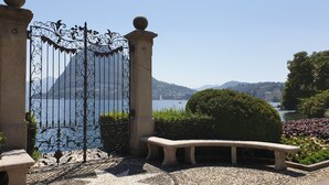 A stone gate with a star-patterned mosaic floor, leading to a scenic view of a lake and mountains. - Hotel San Carlo (Lugano)