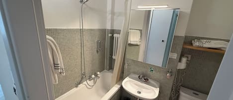 Un baño con ducha, lavamanos e inodoro.