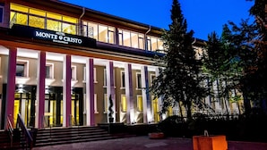 Un hotel amb una entrada destacada, columnes grans i un rètol que diu "Monte Cristo".