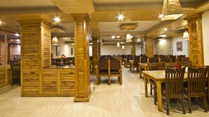 Un comedor espacioso con muebles de madera y un techo alto.