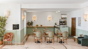 A hotel lobby with a breakfast bar, seating area, and a reception desk. - Hotel Riviera (Anzio)