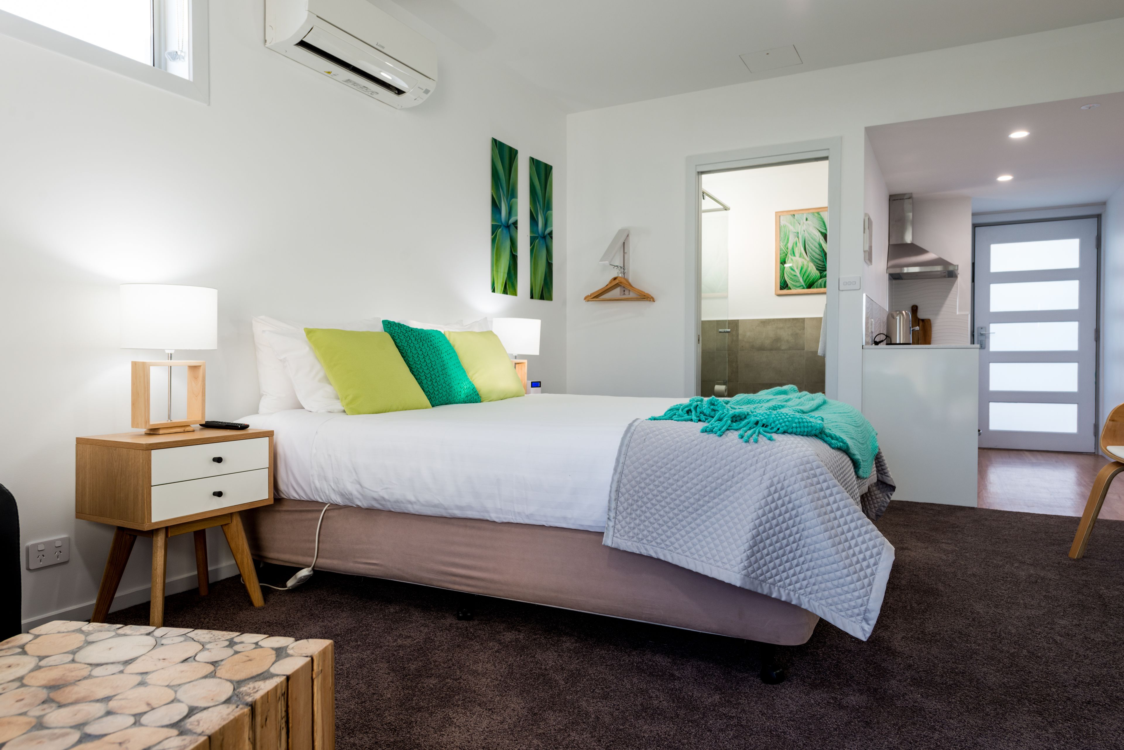 A modern bedroom with a bed, bedside table, and a small table with a patterned top.