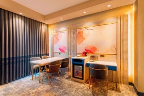 A modern hotel room with a dining area, a minibar, and a large window with curtains. - Starton Hotel & SPA (Ankara)