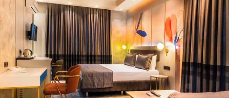 Una habitación de hotel con una cama, un escritorio, una silla, un sofá y una mesita.