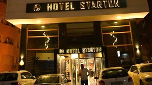 L’entrée d’un hôtel, avec une enseigne indiquant « HÔTEL STARTON ».