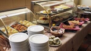 A buffet with various food items and stacked plates. - Hotel Solar da Beira (São Francisco do Sul)