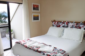 A hotel room with a bed, a window with curtains, and two framed pictures on the wall. - Hotel Solar da Beira (São Francisco do Sul)