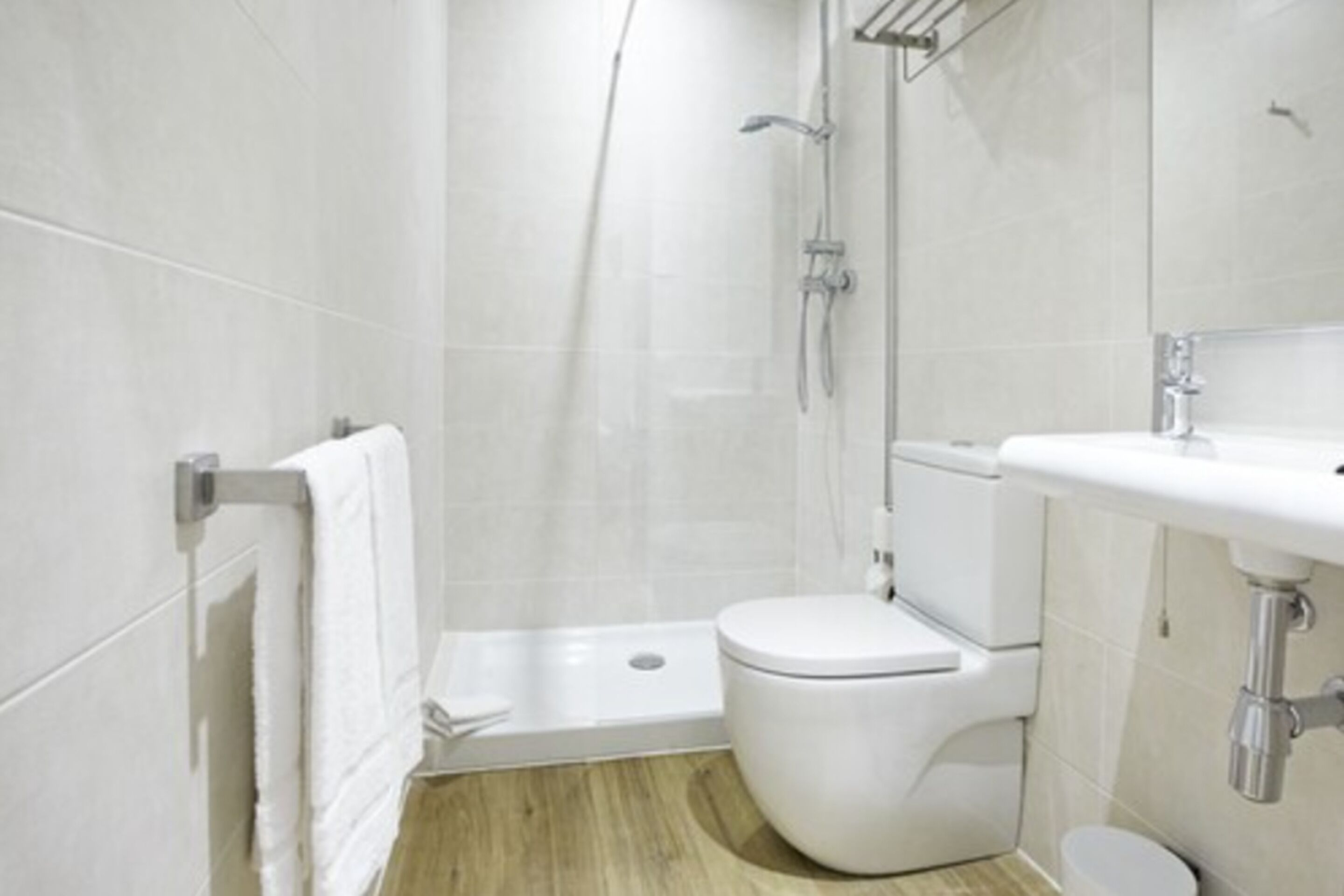 Un baño moderno con ducha, inodoro y lavamanos.