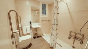 Un baño moderno con inodoro, lavamanos y ducha.
