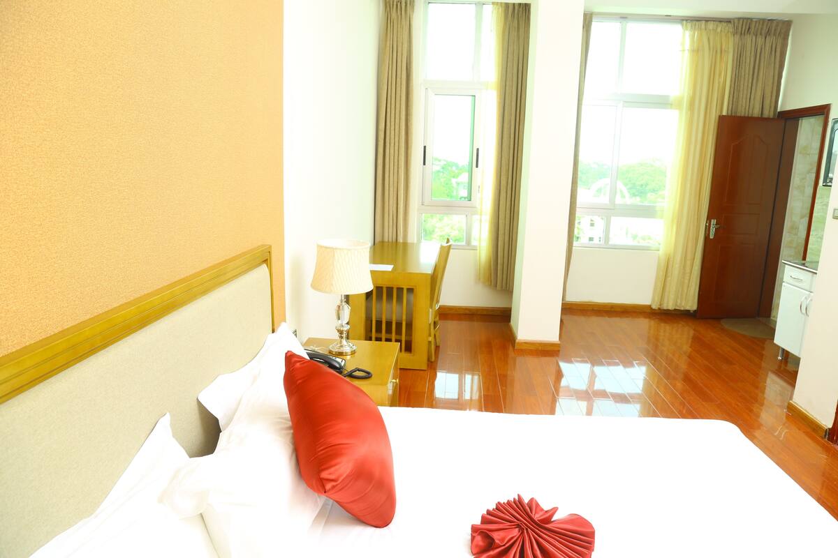 A hotel room with a bed, a desk, and a chair.