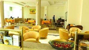 A hotel lobby with yellow chairs, tables, and a reception desk. - Heron Hotel (Awassa)