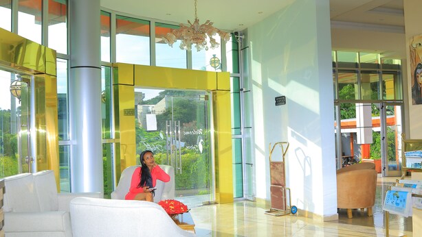 A modern lobby with large windows, a chandelier, and a reception desk. - Heron Hotel (Awassa)