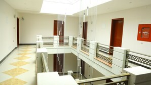 A multi-level interior with a central open space, railings, and doors. - Heron Hotel (Awassa)