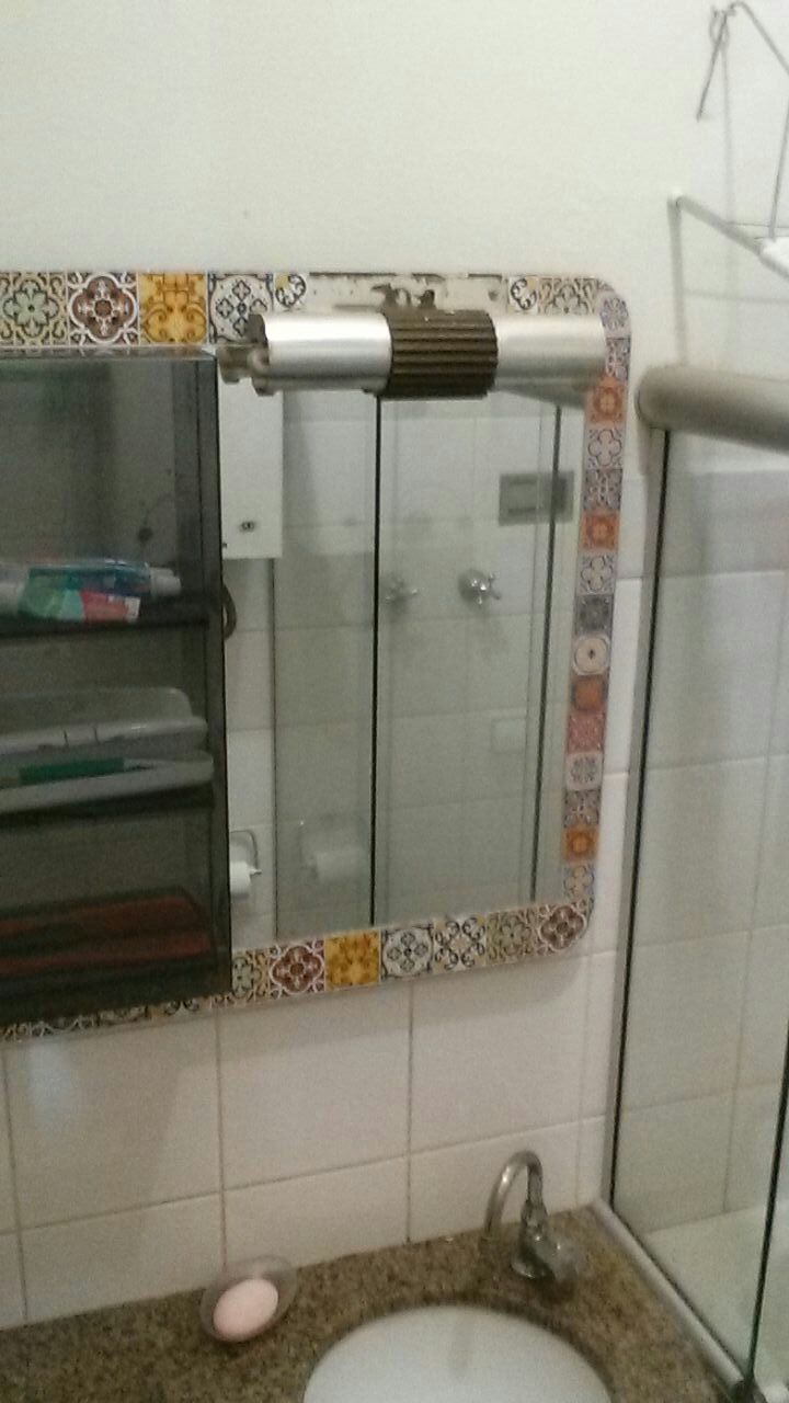 A bathroom with a mirror, a sink, and a shower area.