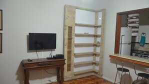 A room with a wooden desk, a television, and a corner shelf unit. - Copacabana Etrusco Apartment (Rio de Janeiro)