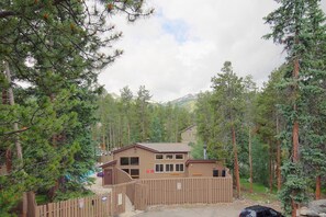 A lodge with a wooden exterior, surrounded by tall pine trees and a mountain in the background. - The Lift C112 (Breckenridge)