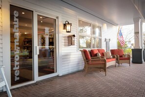 A porch with wicker furniture and a brick floor. - Bar Harbor Motel (Bar Harbor)