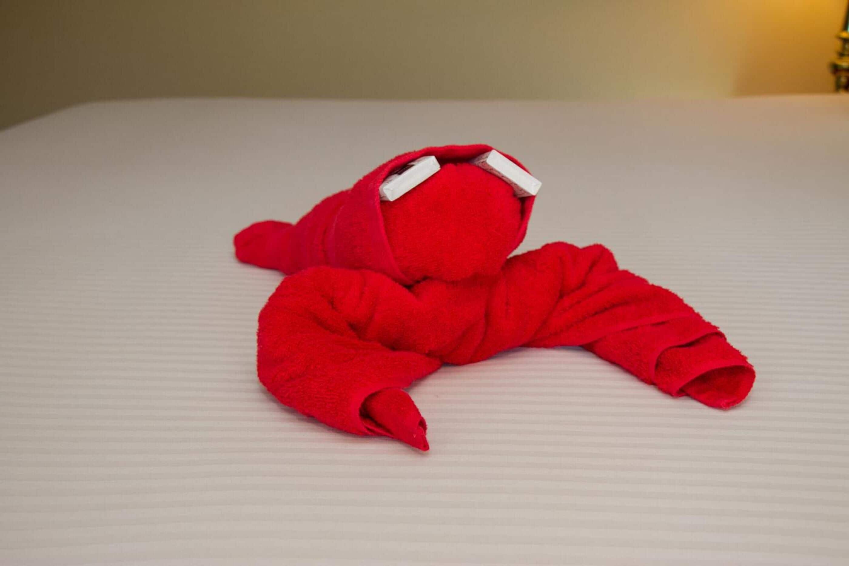 A red plush toy on a bed.
