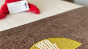 A bed with a brown cover and a logo on it.