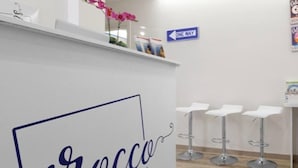 A reception desk with a sign reading "Sirroccas Suites" and a "ONE WAY" directional sign on the wall.