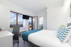 A hotel room with a bed, a desk, a chair, a TV, and a window with a view. - Sirocco Suites (Sant'Agnello)