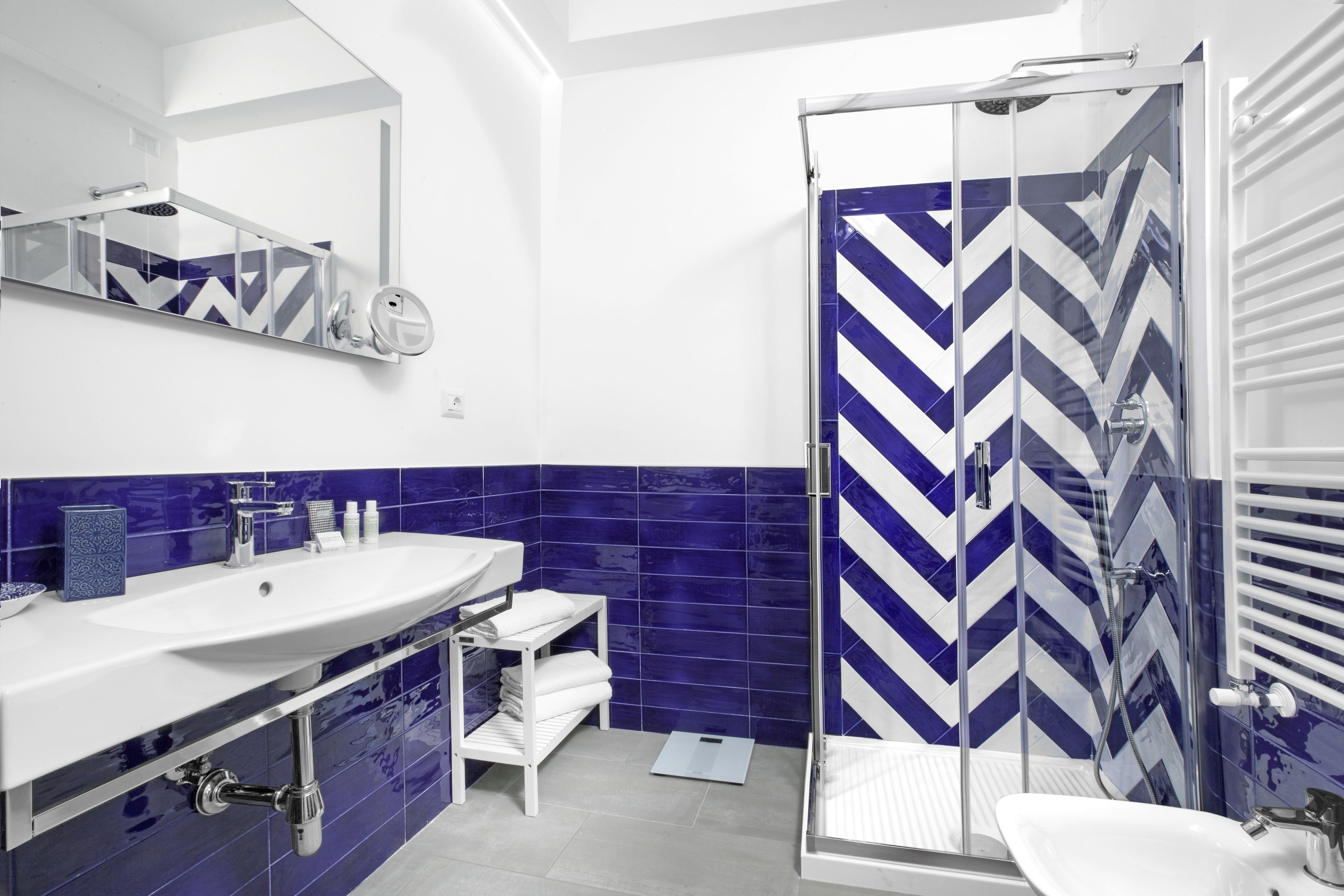 A modern bathroom with a large sink, mirror, and shower area.