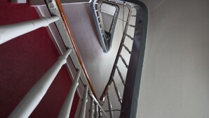 A staircase with white railings and a red carpet. - Stadthotel Kleiner Berg (Friedrichshafen)