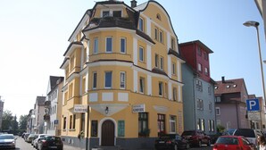 A yellow building with a sign reading "Stadthotel Kleiner Berg" and a "P" parking sign. - Stadthotel Kleiner Berg (Friedrichshafen)