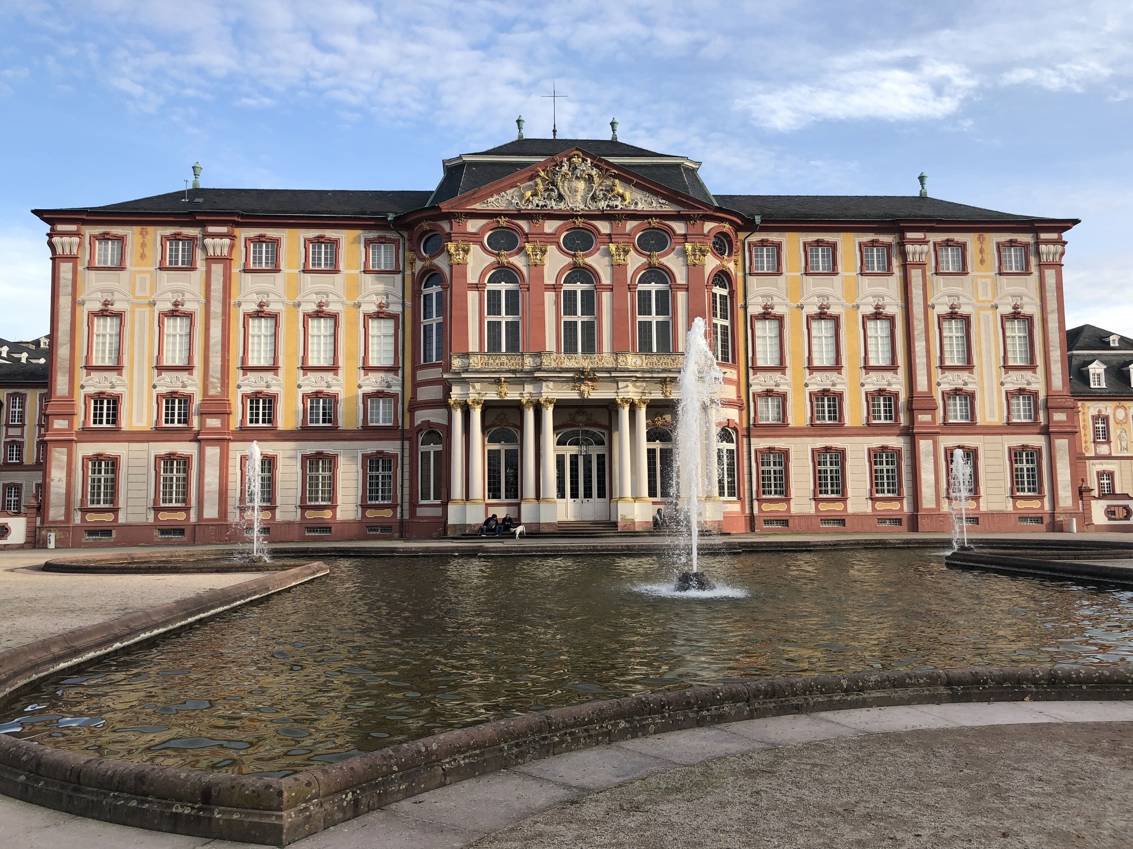 A large, ornate building with a central fountain and multiple windows.