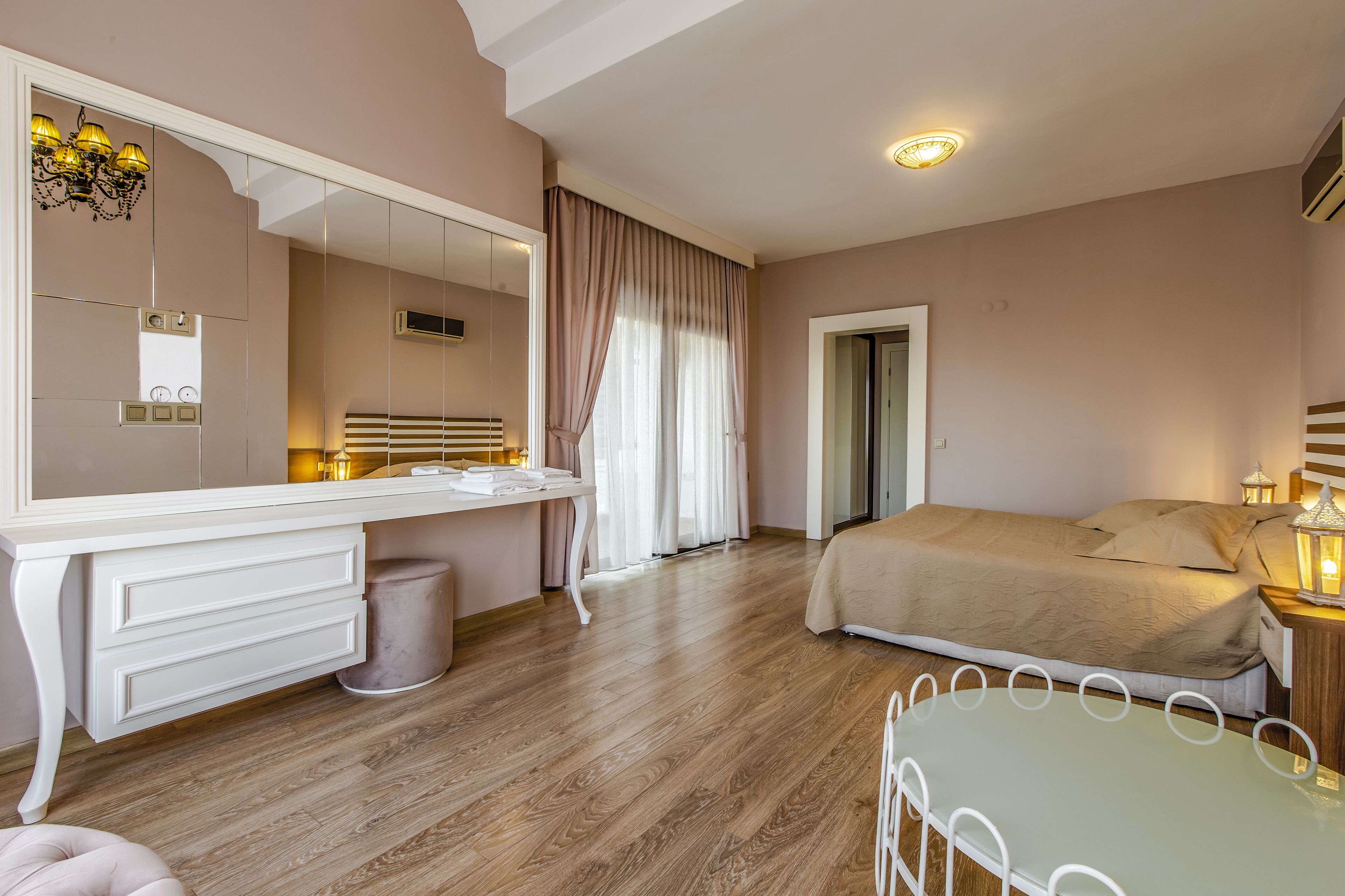 Un dormitorio con cama, mesita de noche, tocador, espejo, cómoda y tocador con lavabo.