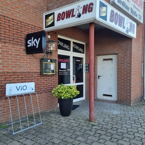 A bowling alley entrance with a sign for 'BOWLING' and a 'sky' sign above it. - Müritz-Pension Waren (Waren (Müritz))