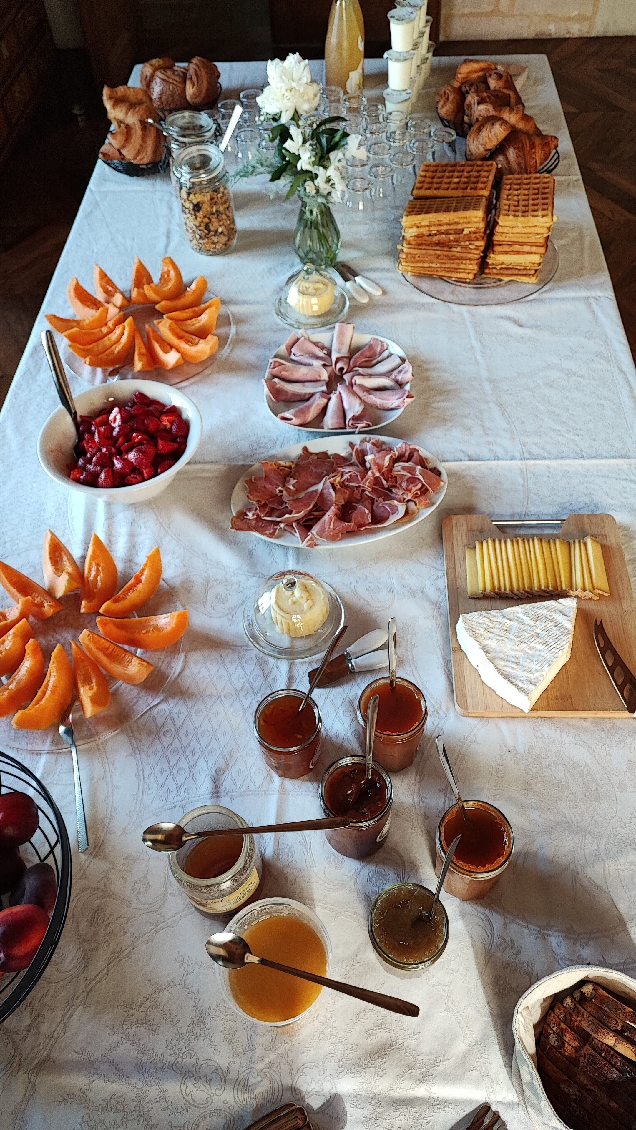 A table with various food items including pastries, meats, and fruits.