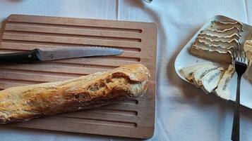 Une table où sont disposés divers aliments, notamment des tranches de pain, des pâtisseries et une variété de condiments.