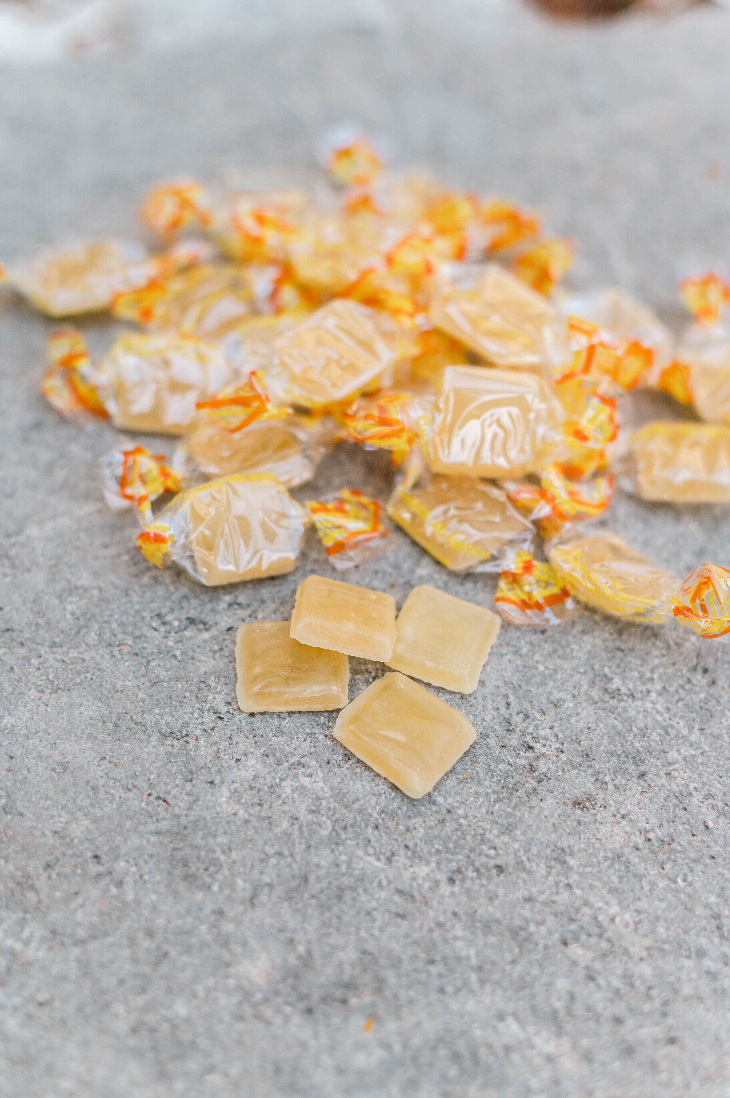 A pile of wrapped candies on a textured surface.