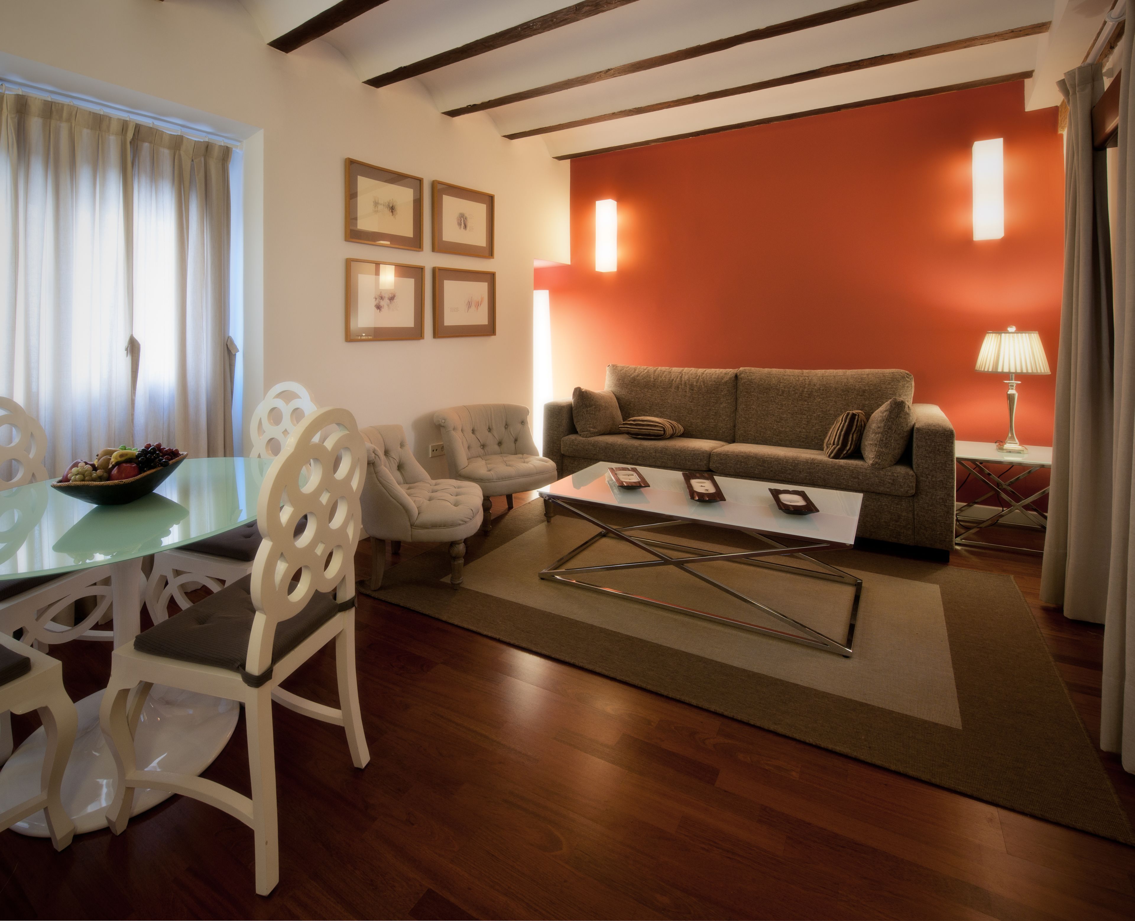 Una sala de estar con un sofá, sillones, una mesa de centro y una mesa de comedor con sillas.