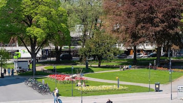 En park med ett blomsterland, ett cykelställ och en staty.
