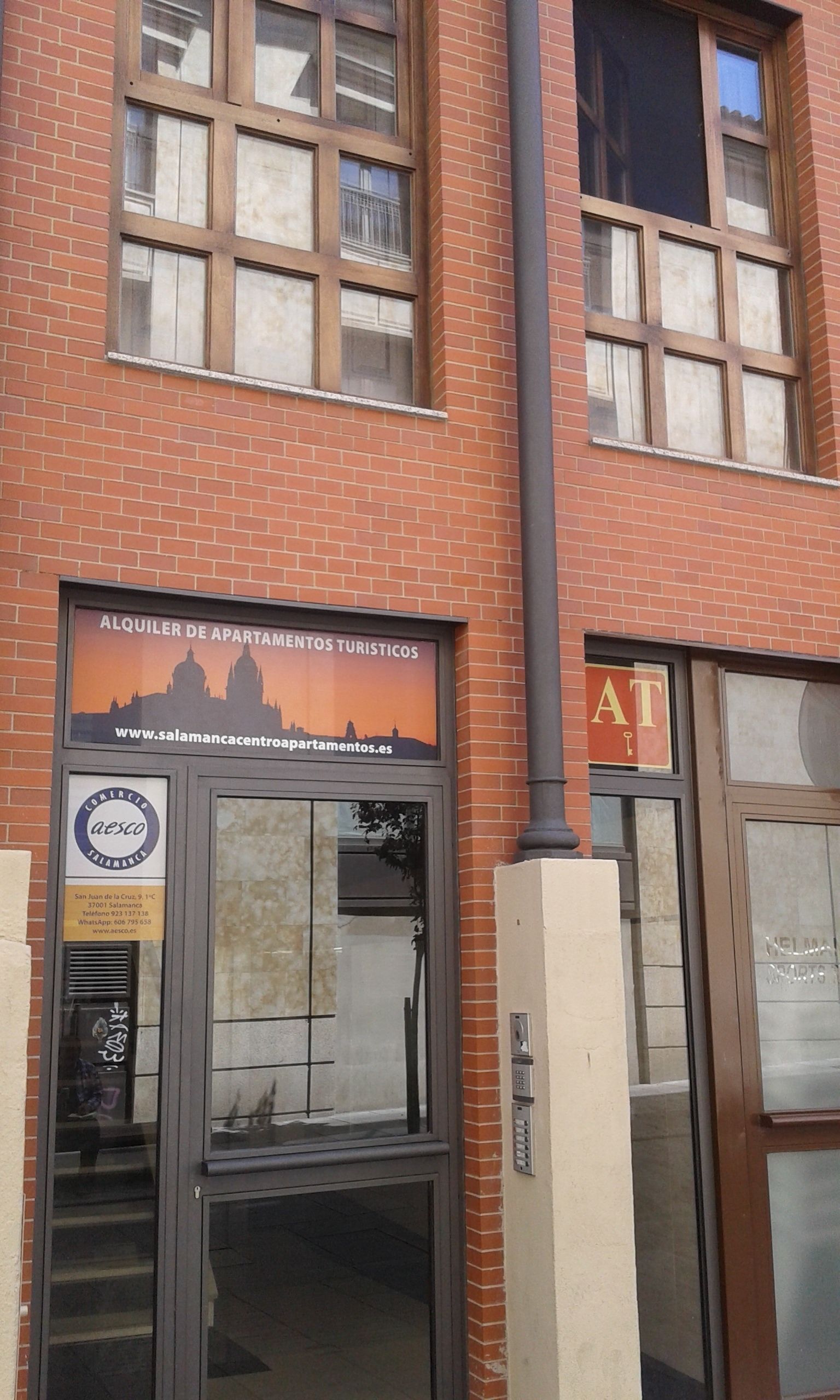 A building with a sign for 'Alquiler de Apartamientos Turísticos' and a logo for 'Aesco Salamanca'.