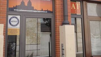 A building with a sign for 'Alquiler de Apartamientos Turísticos' and a logo for 'Aesco Salamanca'.