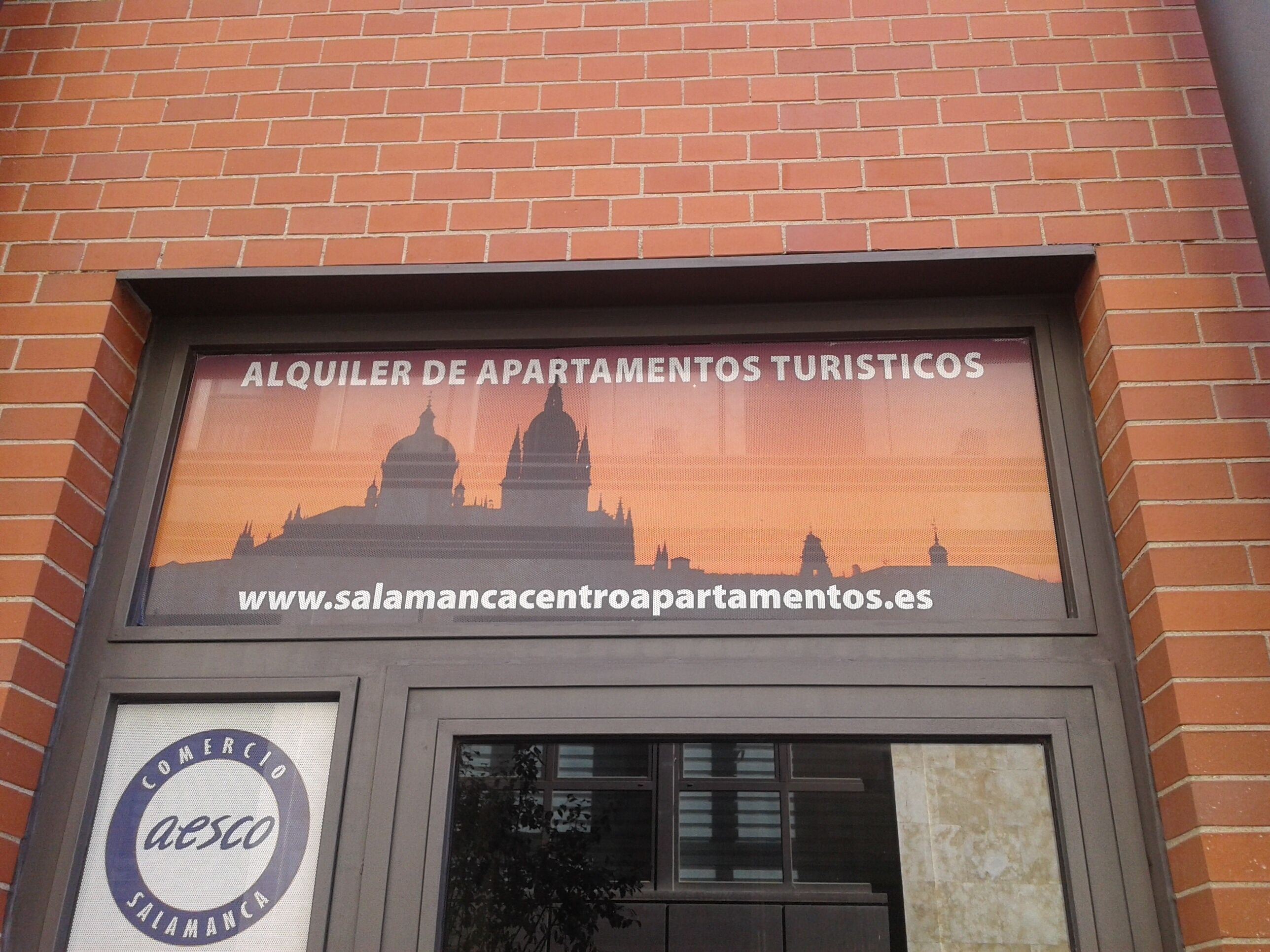 Señal para 'Alquiler de Apartamentos Turísticos' con una dirección web.