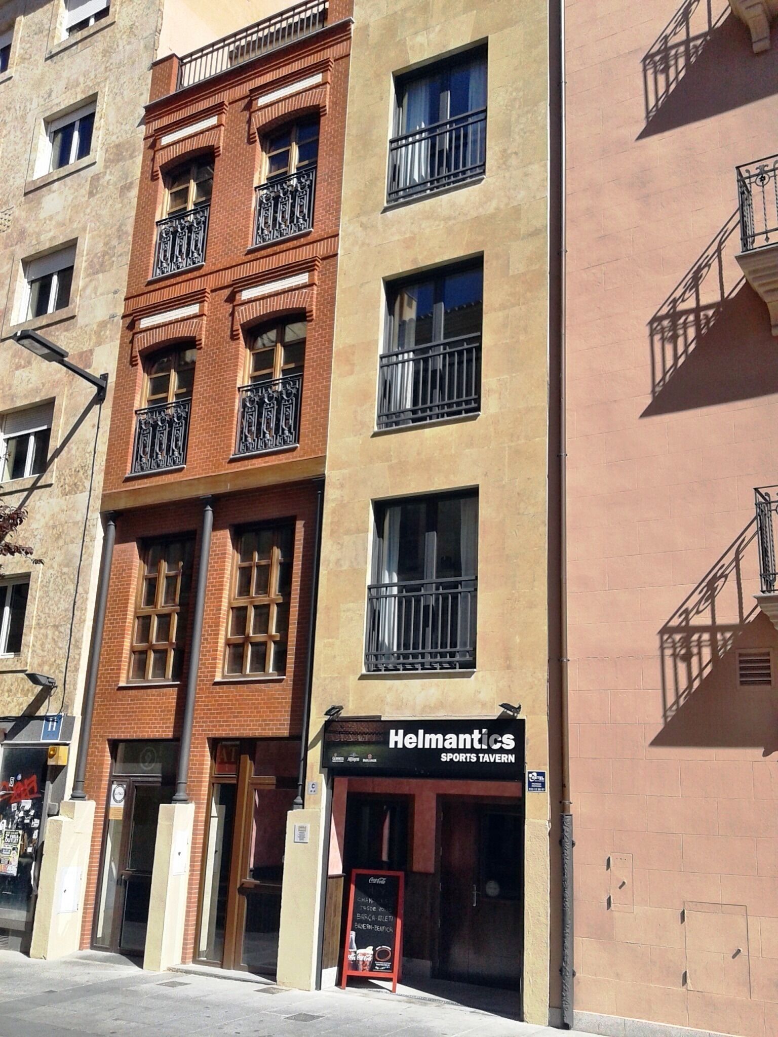 Un edificio a più piani con un locale sportivo chiamato "Helmantics" al piano terra.