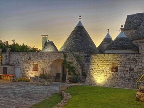 A historic stone building with multiple conical roofs and a paved courtyard.