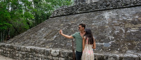 Una costruzione in pietra con tetto piatto e un muro in pietra in primo piano.