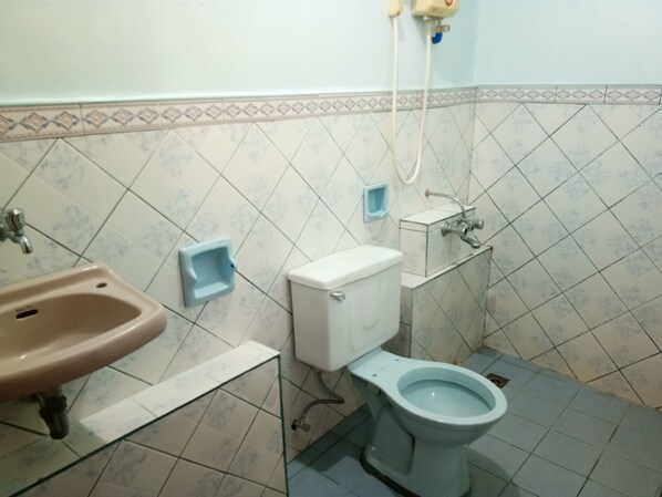 A bathroom with a sink, toilet, and bidet.