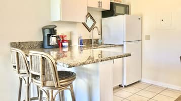 Deluxe King Suite | Private kitchenette | Fridge, microwave, coffee/tea maker, cookware/dishes/utensils