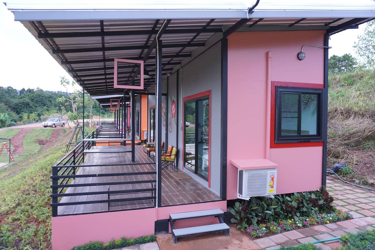 Um edifício moderno com área externa coberta, uma cesta de basquete e um pequeno aparelho de ar condicionado.